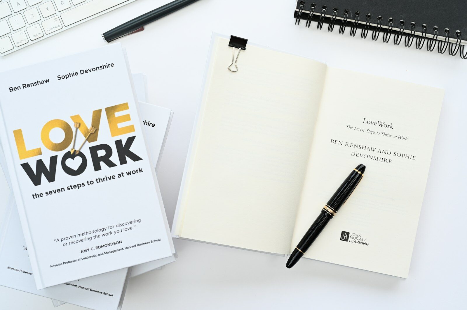 a notebook with a pen on top of it next to a keyboard